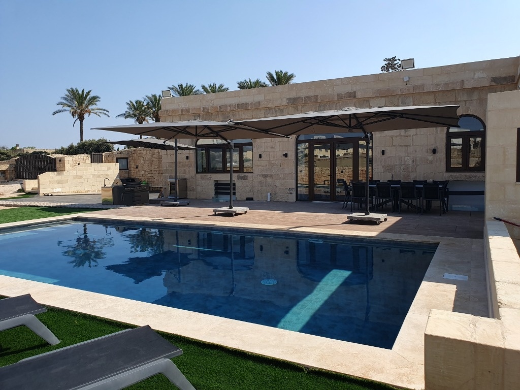 Ir-Razzett tal-Mastru &mdash; Private Maltese farmhouse pool terrace, sunshades, and limestone facade